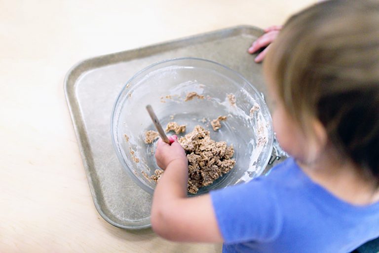 Toddler mixing with spoon and bowl