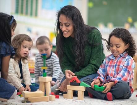 montessori teacher with students playing with blocks